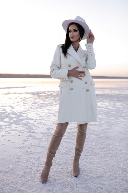 Pretty girl in white coat in winter shoes European girl in coat smiling on a cold day Cheerful brunette lady having fun during modern photo shoot salt lake