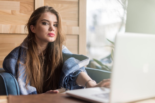 Pretty girl with laptop and cup of tea in a coffee shop