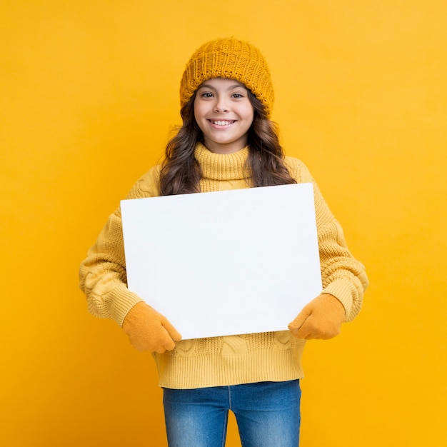 Foto gratuita ragazza graziosa con un poster in mano