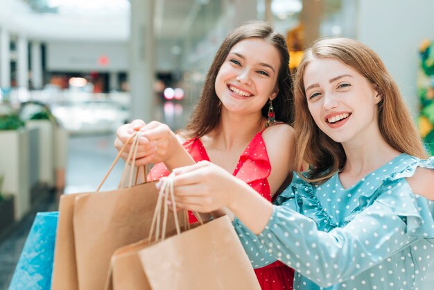 Pretty girls posing with shopping bags