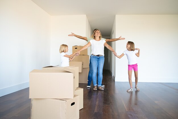 Pretty girls and their dad showing their new flat to happy mom