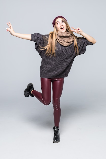 Pretty happy smiling young model in fashioned casual clothes dark sweater on white with shadows