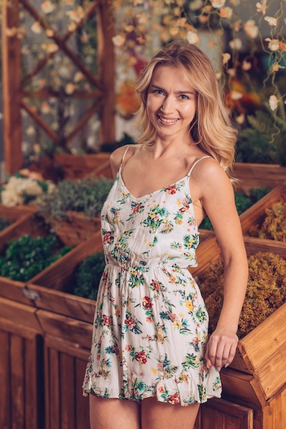 Pretty happy young woman standing in front of wooden crate