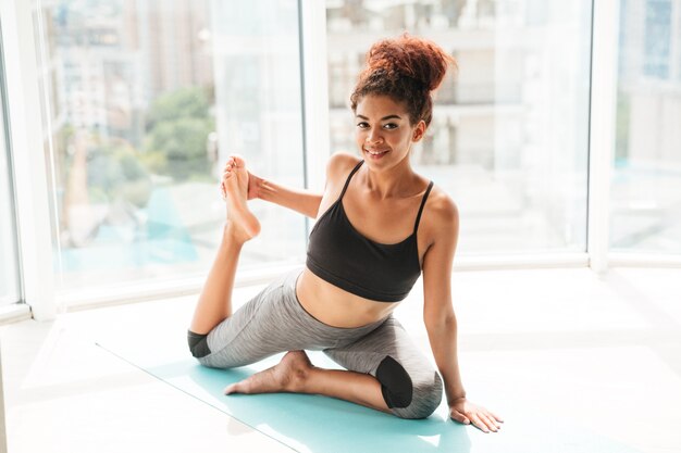 Pretty healthy woman making difficult exercise on floor