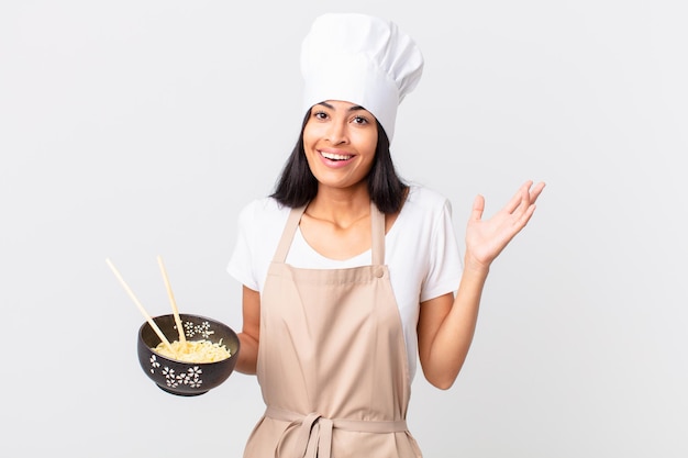 Premium Photo Pretty Hispanic Chef Woman Looking Surprised And Shocked With Jaw Dropped Holding An Object And Holding A Noodle Bowl