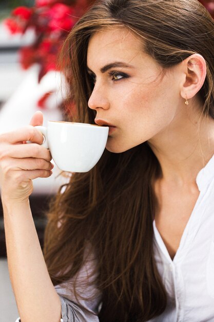 美しい女性はコーヒーを飲みます