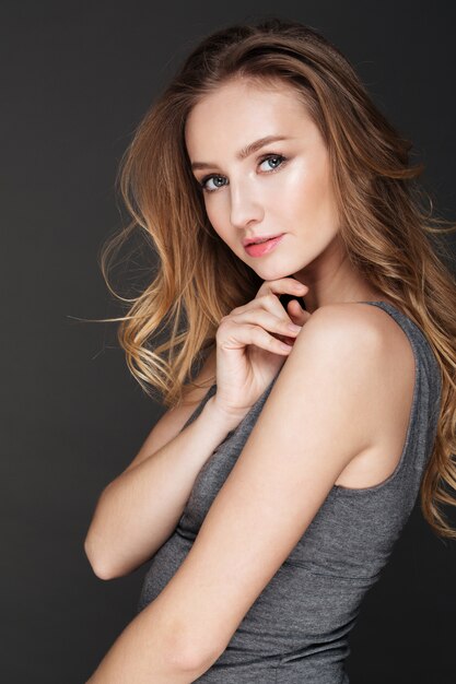 Pretty lady posing over dark wall