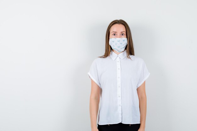 Pretty lady in t-shirt with mask posing while standing and looking confident