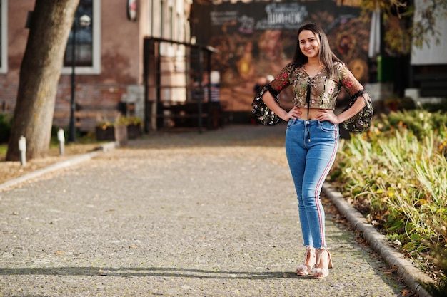エクアドルのかわいいラテン系モデルの女の子がストリートでポーズをとったジーンズに着用