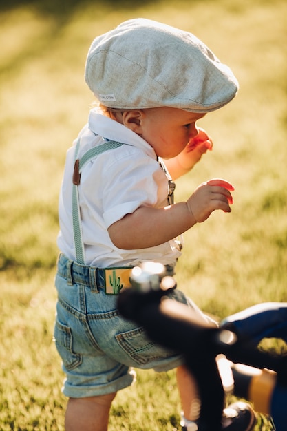 スタイリッシュな服を着たかわいい白人の男の子が両親と一緒に庭に歩いて行く