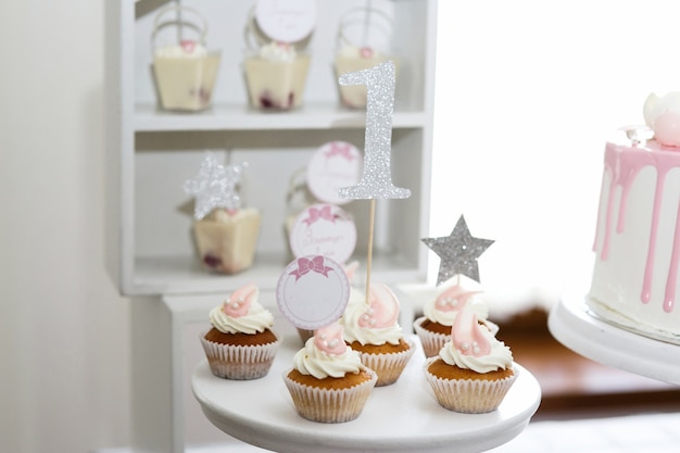 Pretty little cupcakes with white cream served on white dish 