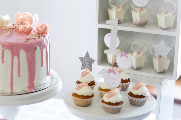 Pretty little cupcakes with white cream served on white dish 