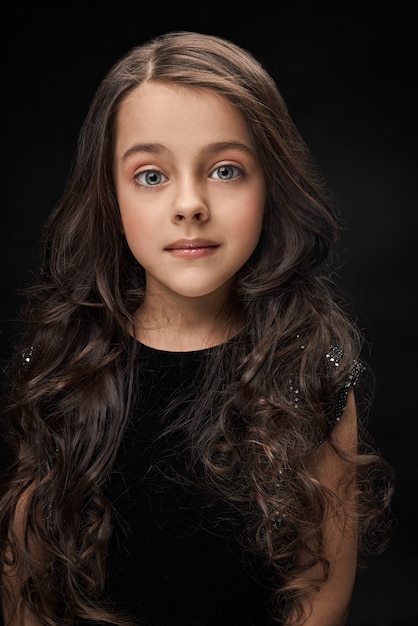 Pretty, little girl in black dress posing.