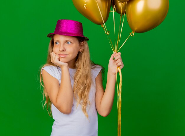 Baloons의 무리와 함께 휴가 모자에 예쁜 소녀