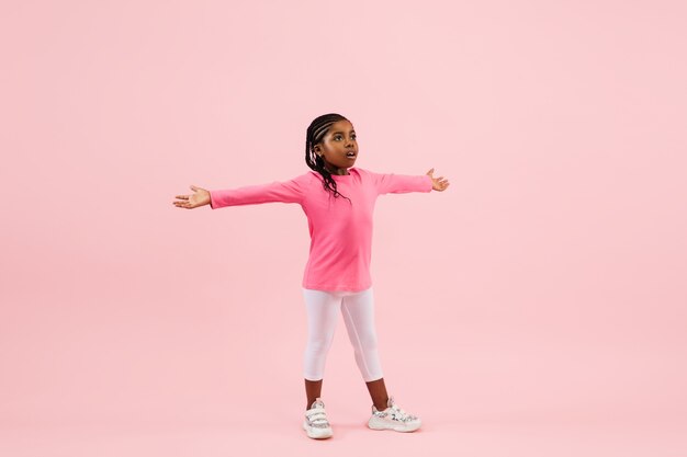 Pretty little girl isolated on coral pink  background.