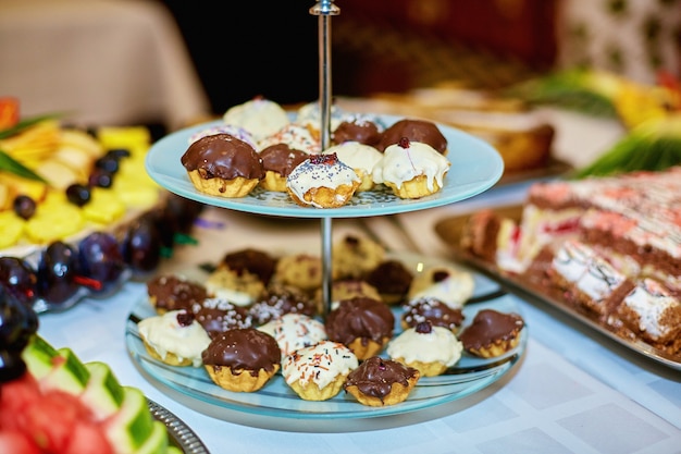 Pretty little white and brown cupcakes stand on the tired dish