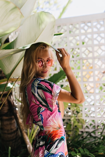 Pretty long-haired woman wears summer dress looking over shoulder with interest.