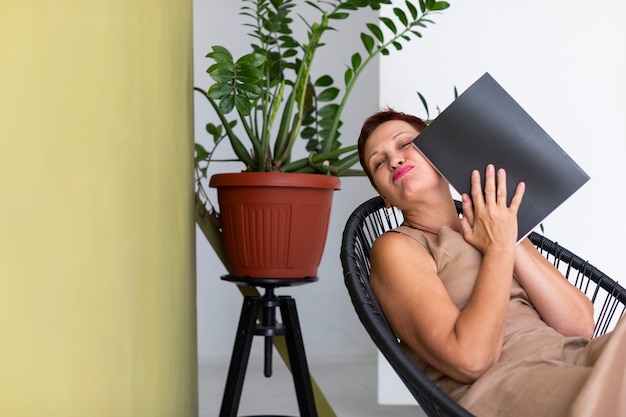 Free photo pretty mature lady with magazine posing