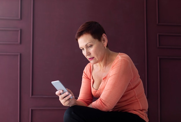 Telefono di lettura rapida della donna abbastanza matura