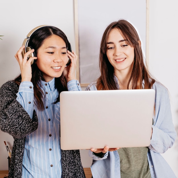 Pretty multiracial women with laptop and headphones