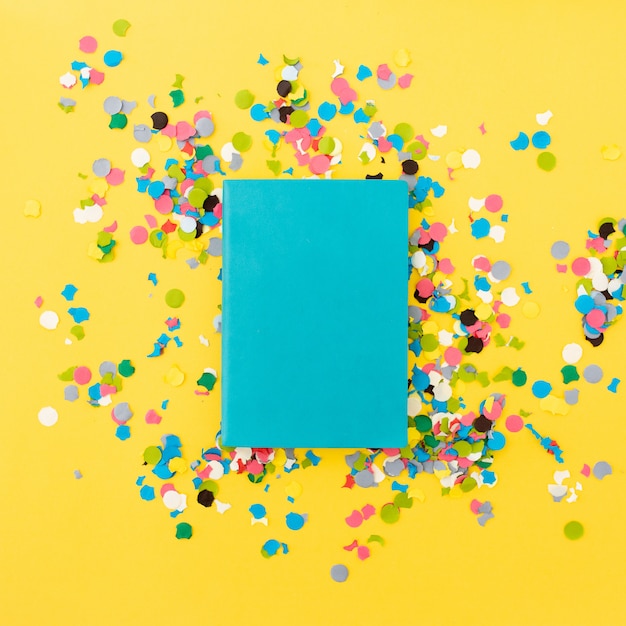 Free photo pretty notebook for mock up on yellow background with confetti around