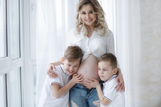pretty pregnant woman with cute children at home