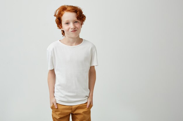 Pretty red head boy in white t-shirt looking with unsatisfied expression when friend refused go to cinema with him.