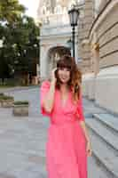 Free photo pretty romantic woman in pink dress posing outdoor in old european ity.