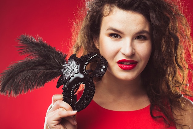 Pretty seductive woman posing with black mask