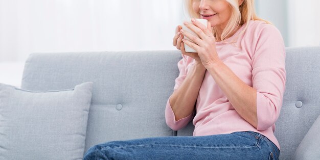 自宅でコーヒーを楽しんでかなり年配の女性