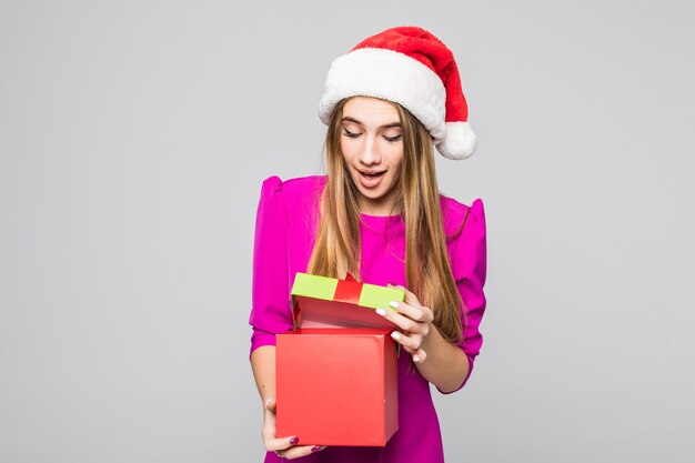 Pretty smiling funny happy lady in short pink dress and new year hat hold box surprise in her hands