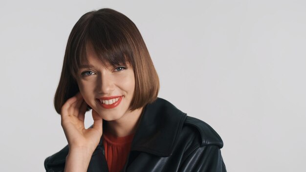 Pretty smiling girl with bob hair happily looking in camera isolated over white background. Good mood expression