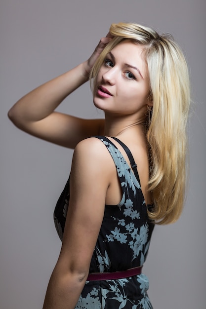 Pretty smiling good-looking beautiful woman isolated against blank studio wall.