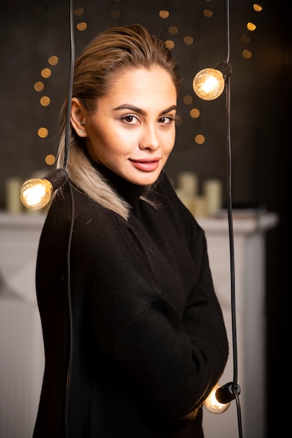 Pretty smiling woman dressed in black sweater and posing