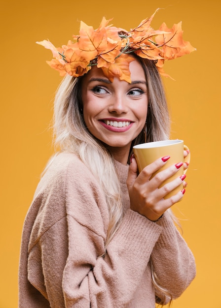 Foto gratuita donna sorridente graziosa che tiene tazza di caffè e distogliere lo sguardo