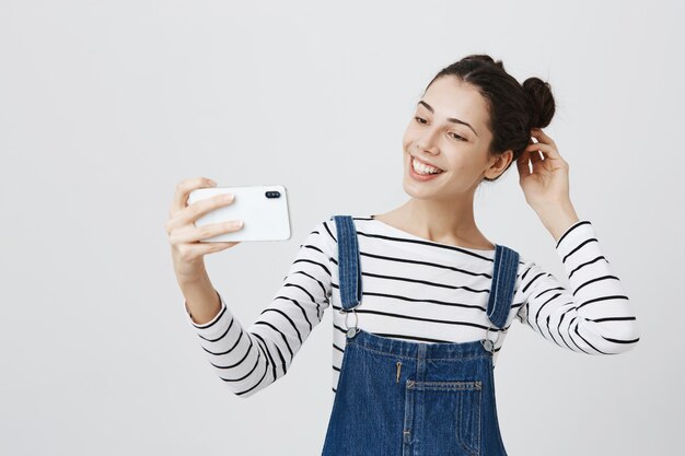 Pretty smiling woman taking selfie on smartphone