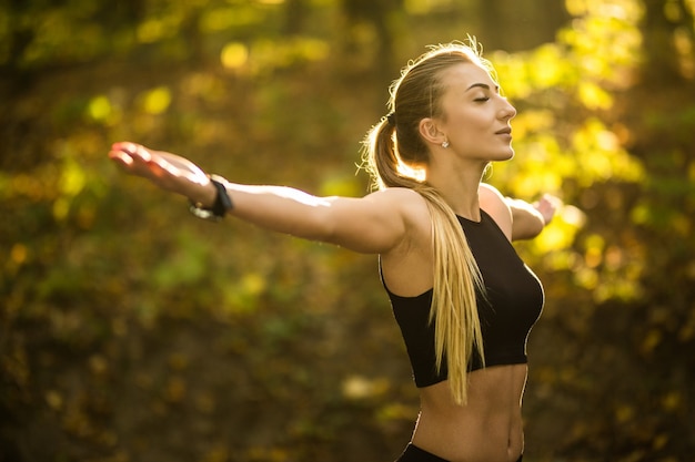 Foto gratuita bella donna sportiva che fa esercizi di yoga nel parco