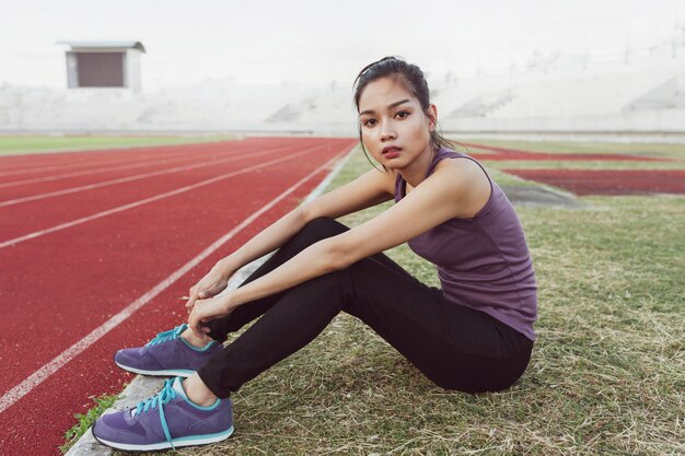 Pretty sportswoman sitting on the lawn