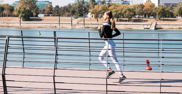 Pretty sporty young woman jogging at park