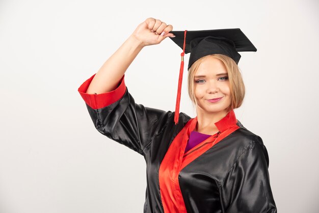 Pretty student posing on white wall. 