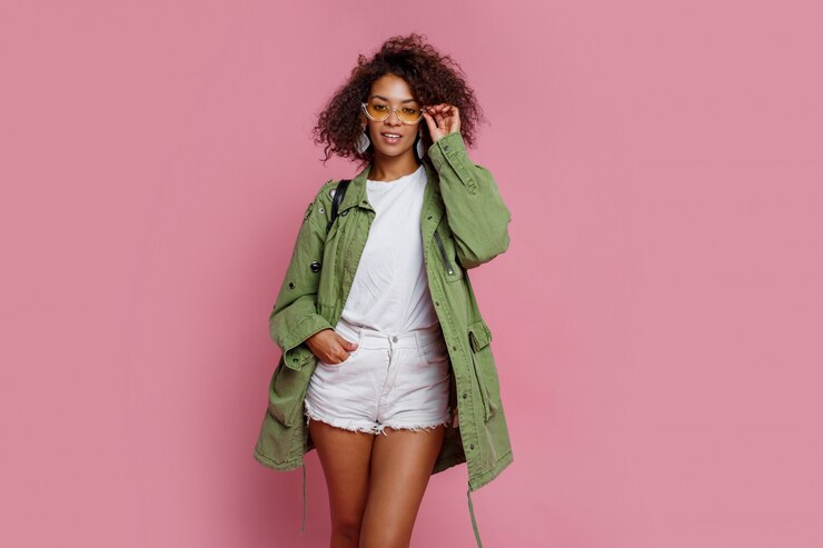 Free Photo pretty stylish black girl in green jacket posing on pink background. winter or spring fashion look..