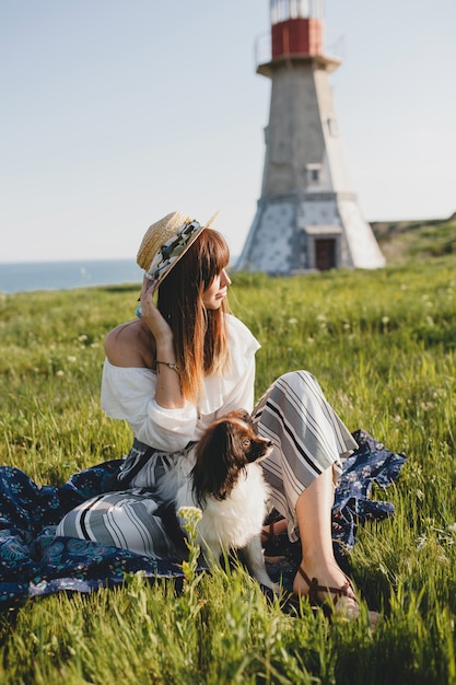 Pretty stylish woman in countryside, with a dog