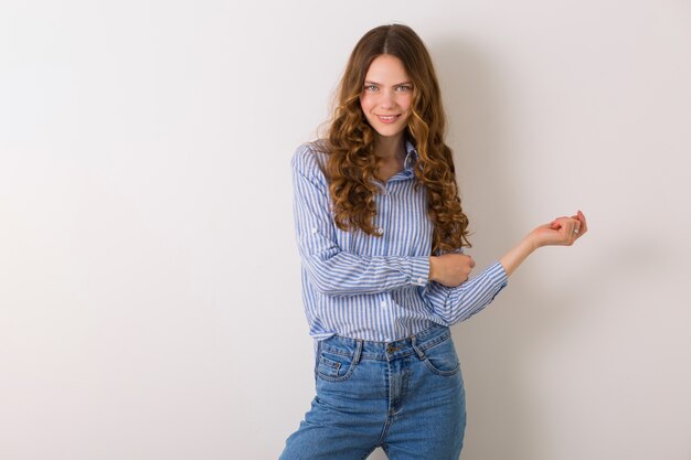 Pretty stylish young woman posing in denim style outfit on white