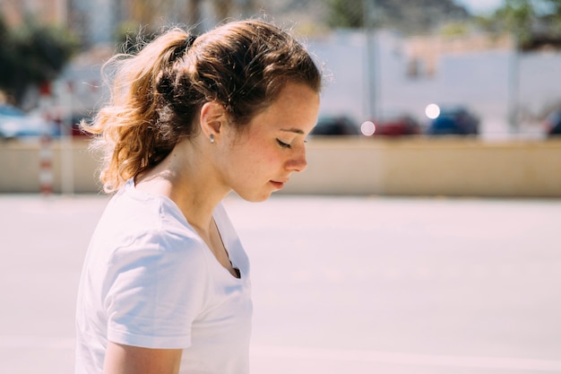 Pretty teen girl looking down in street