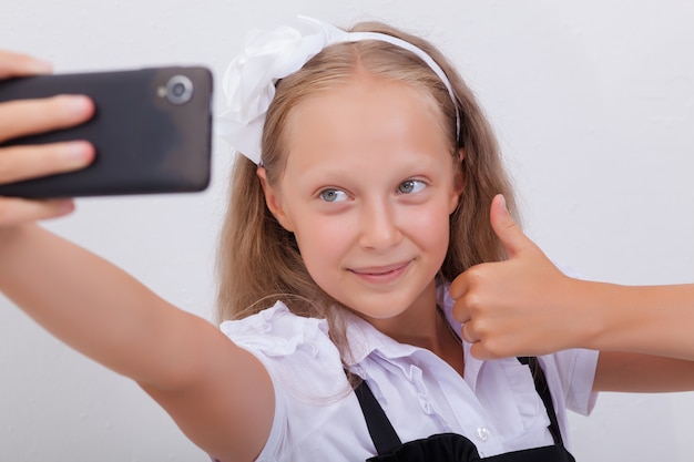 Pretty teen girl taking selfies with her smartphone