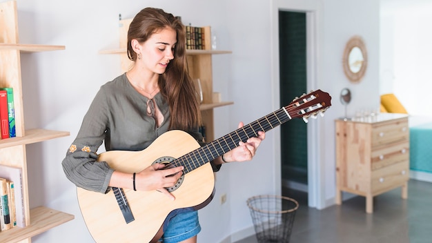 Pretty teenage girl playing guitar