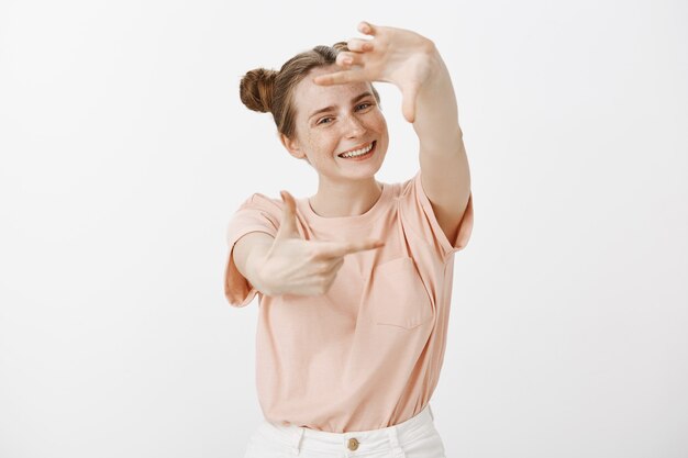 Pretty teenage girl posing against the white wall