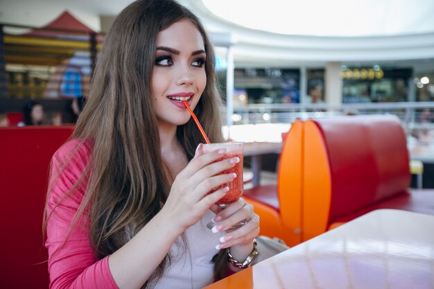 Pretty teenager drinking a soda with a straw