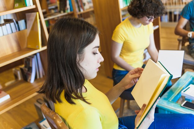 Pretty teenager reading with friend