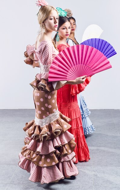 Pretty three young flamenco dancer in beautiful dress.